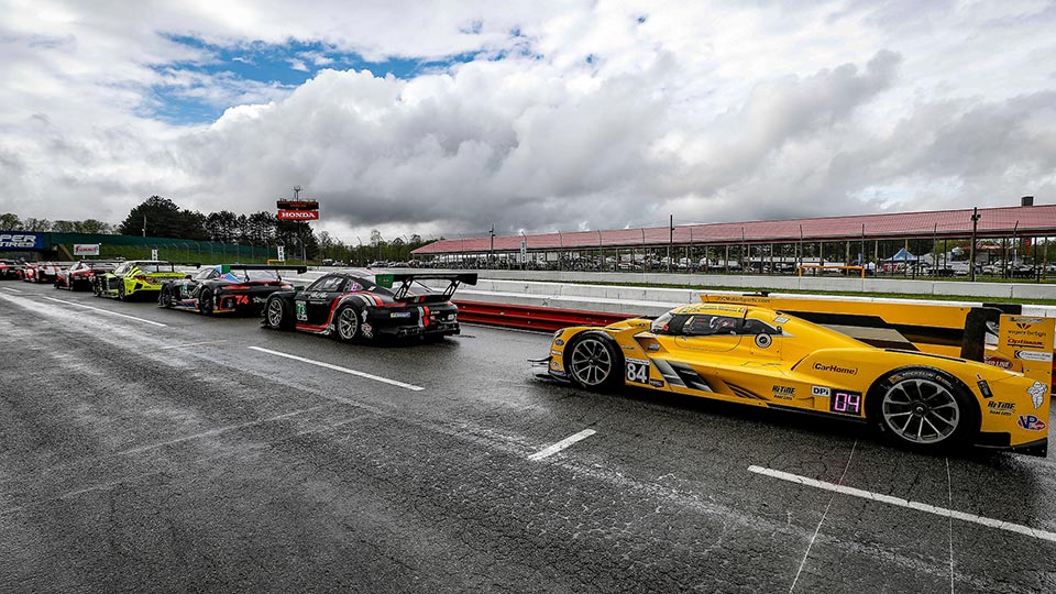 Cars line up on pit road during the Acura Sports Car Challenge